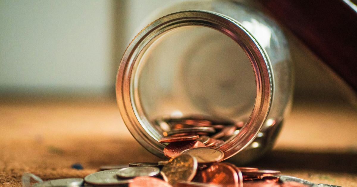 A glass jar tipped over with coins flowing out representing the savings you get when you do preventative maintenance