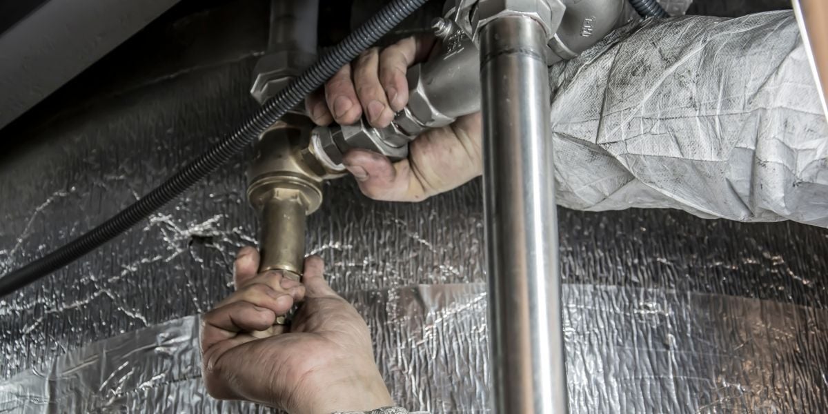 Plumber working on a pipe in a commercial building