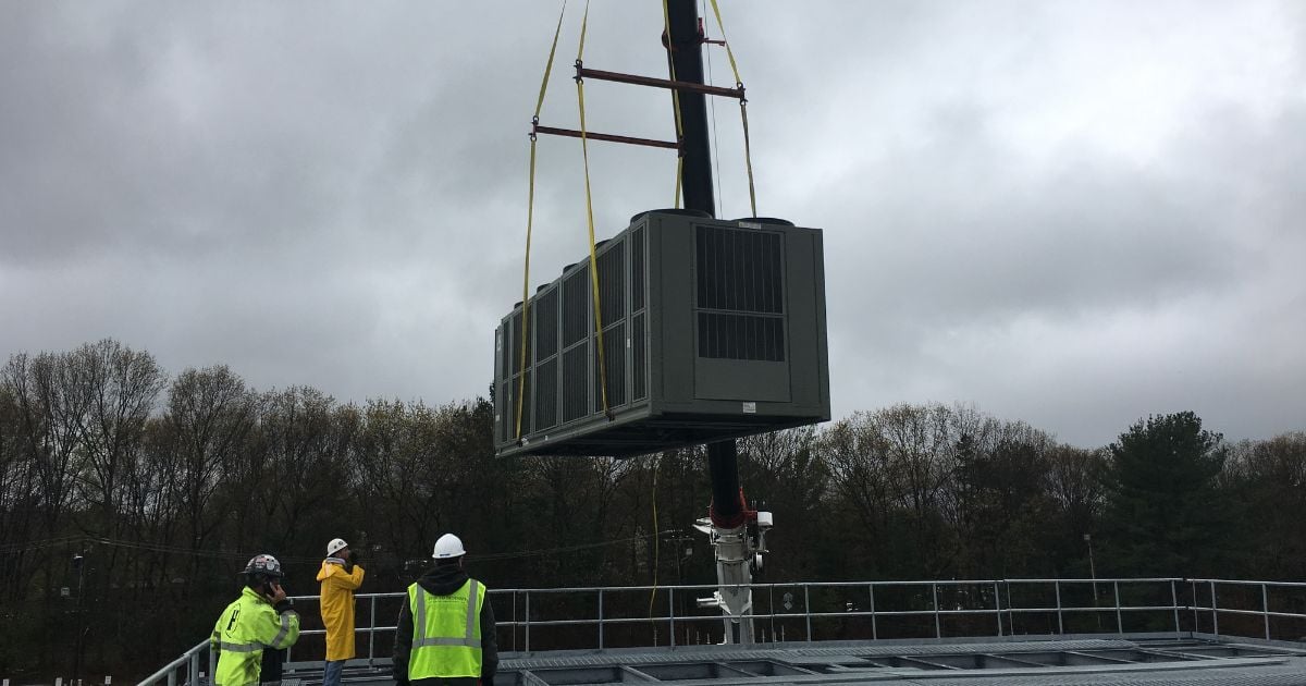 HVAC crew installing rooftop unit