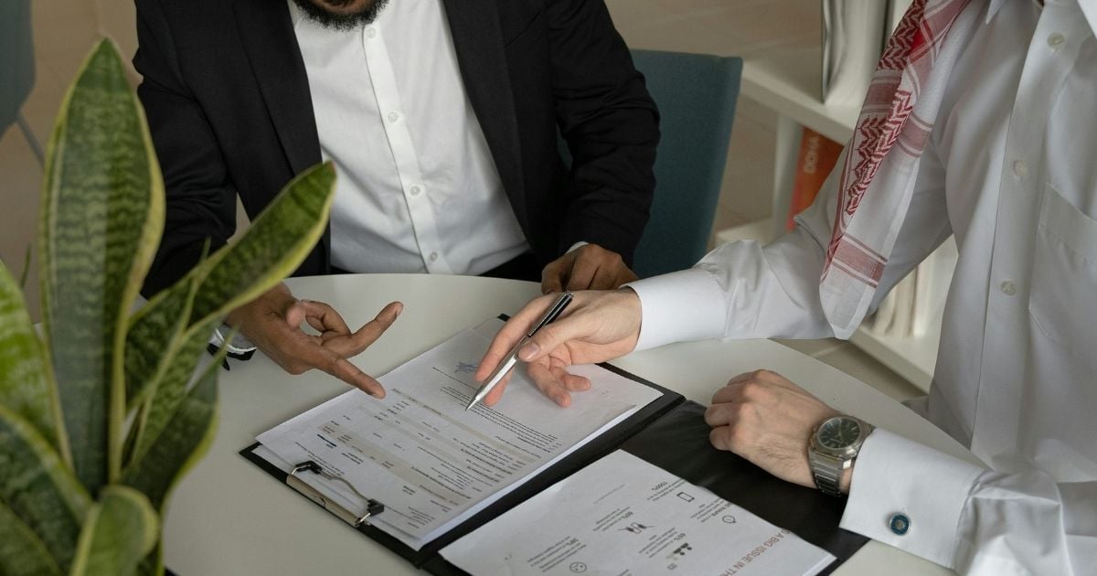 Two People looking over a portfolio with information on it. 
