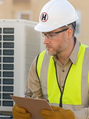 Commercial HVAC technician working on a rooftop unit in Somerville, MA