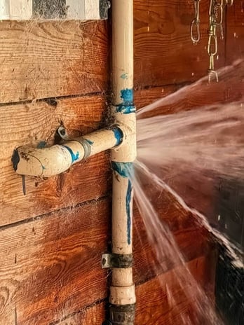 Commercial plumbing pipe spraying water and in need of plumbing service