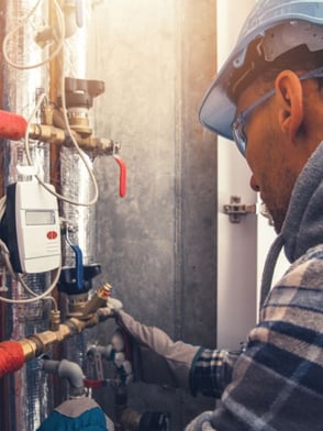 HVAC service technician working on a commercial buildings heating system to make sure everything is running efficiently