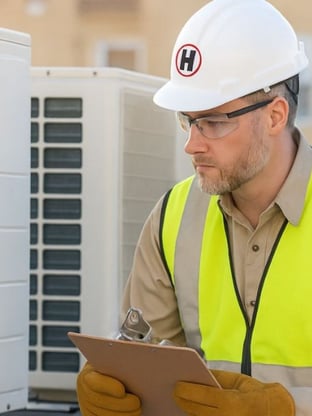 HVAC service tech looking at a commercial buildings HVAC system