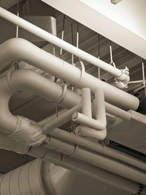 Plumbing pipes in a commercial building representing what parts would need plumbing services