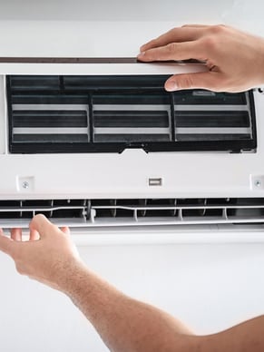 HVAC Technician working on an indoor unit for a service call