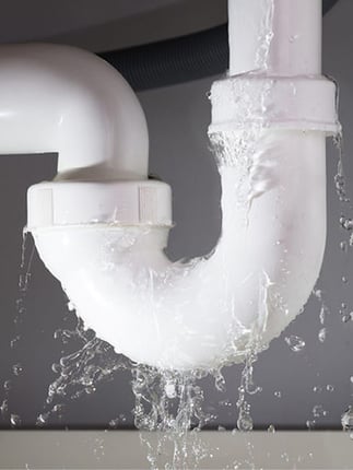 Leaking pipe, representing the plumbing work and repairs that are needed