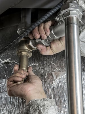 Plumber working on piping for a commercial building