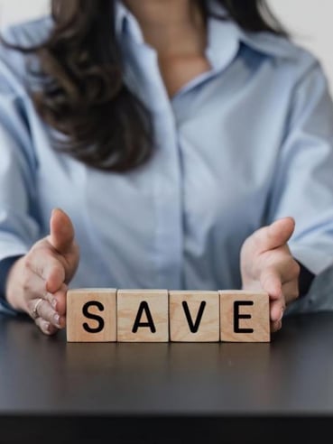 a woman with tiles spelling out SAVE in front of her