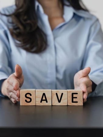 Woman holding a 'Save' sign, symbolizing the cost savings achieved through a preventative maintenance contract for commercial HVAC systems.