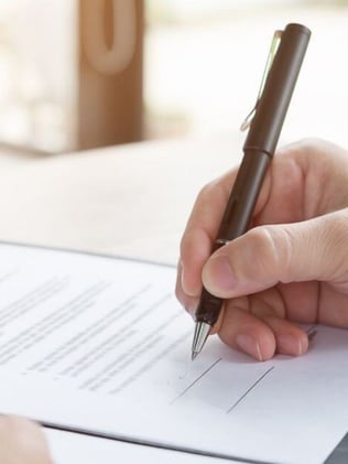 Commercial building owner signing a preventative maintenance contract