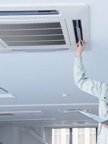 Service technician checking the air filter of a commercial buildings cooling system