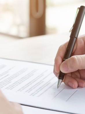 A commercial business owner signing a contract for a preventative maintenance plan