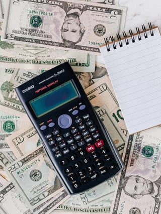 Calculator and money representing energy bills rising due to the economizer not working correctly