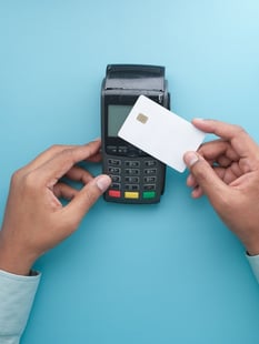 A person using a credit card machine to pay for the rising electricity rates